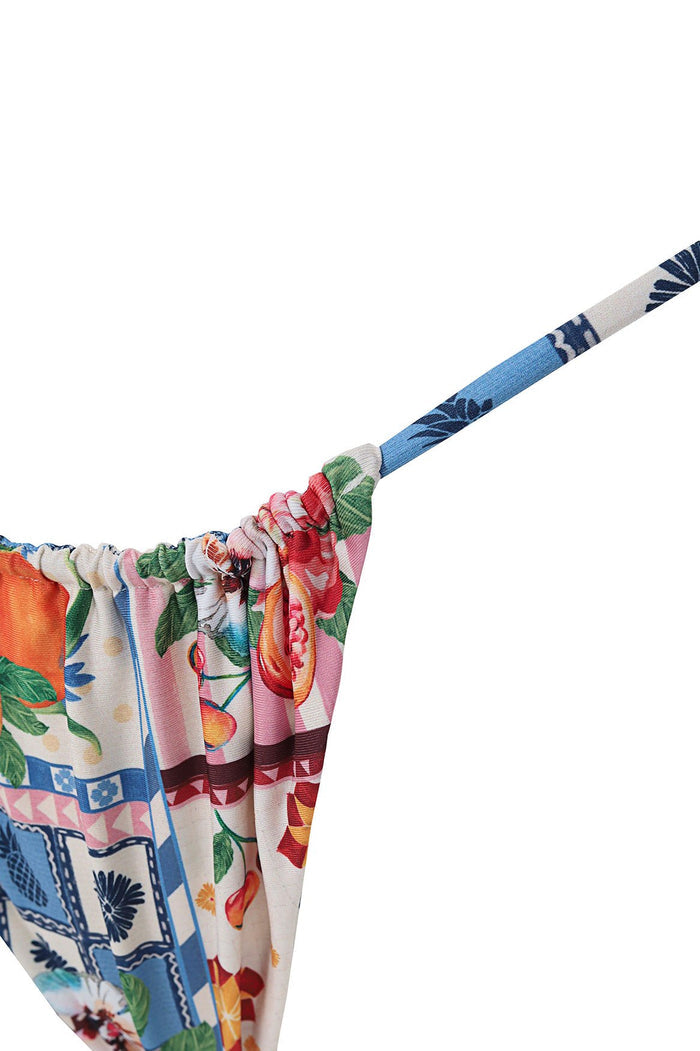 High-rise bikini bottom with gathered waistband and thin straps, featuring multicolor patchwork print with geometric tiles, tropical fruit and foliag…