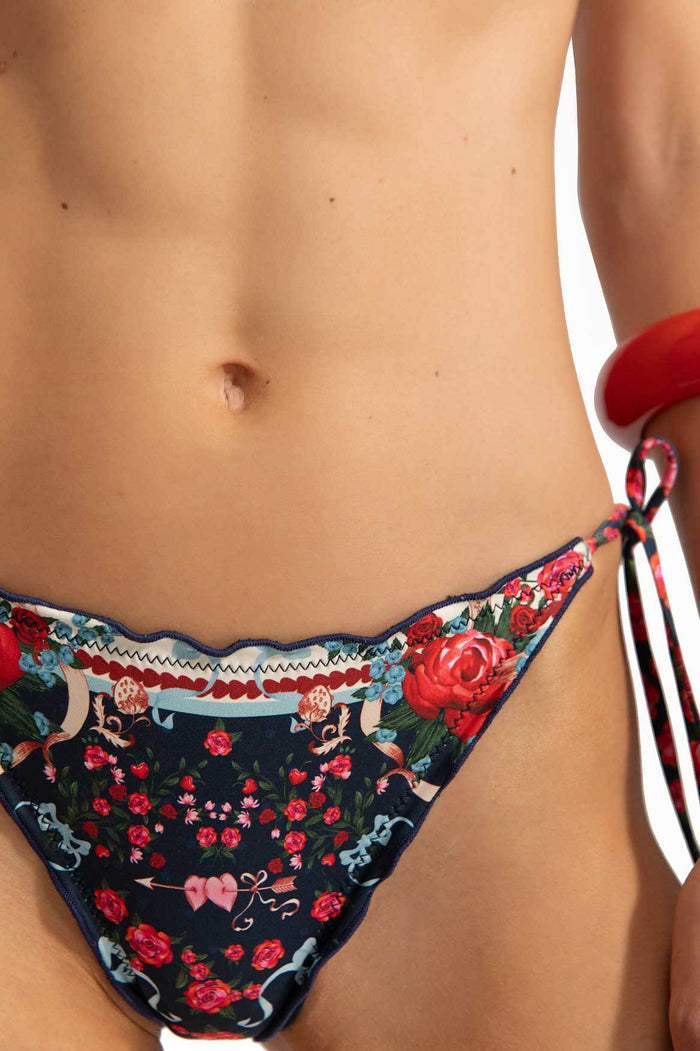 Navy bikini bottom with red and pink pattern detail print, decorative trim with zigzag details, and handmade side ties