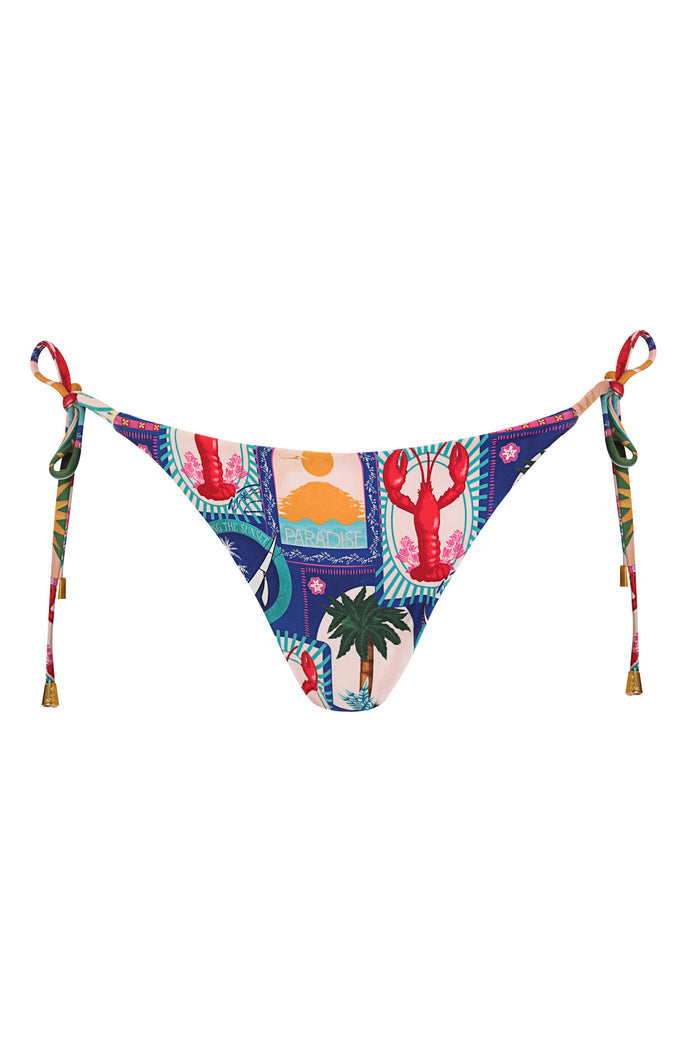 Reversible bikini bottom with side ties and multicolor tropical print featuring lobster, palm tree, sun, and Paradise postcard stamp graphics on navy…