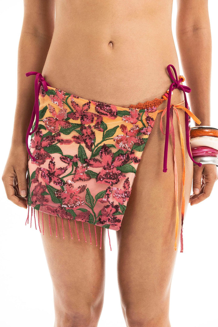 Alessandra wrap skirt with pink and green sequin floral embroidery on mesh base, purple side ties, and beaded fringe hem