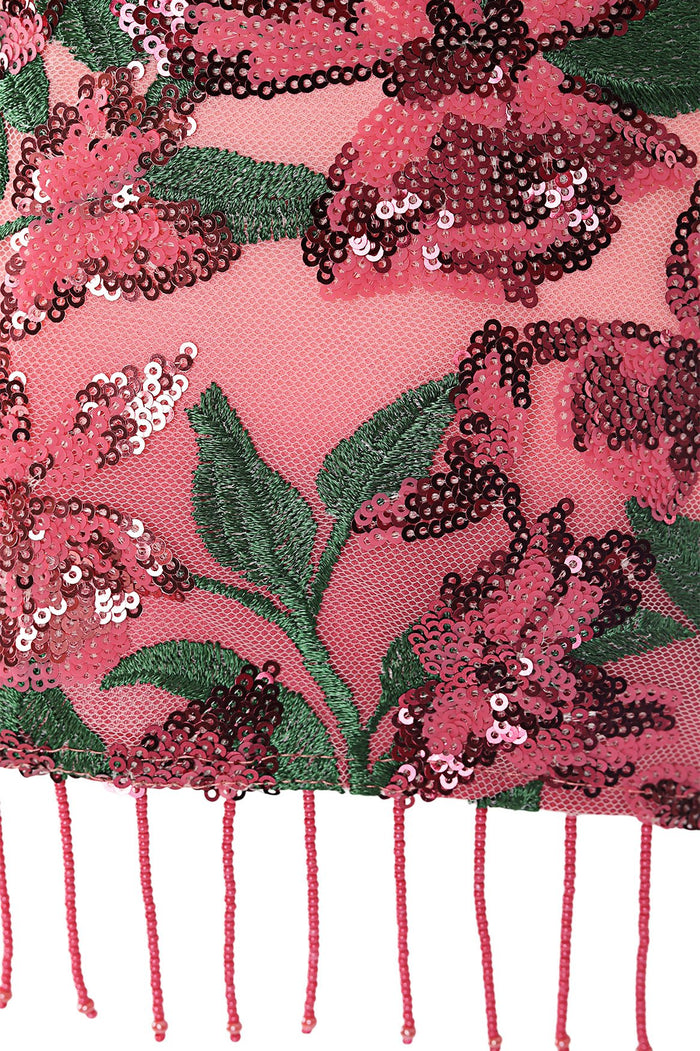 Pink wrap skirt with embroidered mesh featuring sequin floral embellishments in coral and burgundy tones, green embroidered leaves, and beaded fringe…