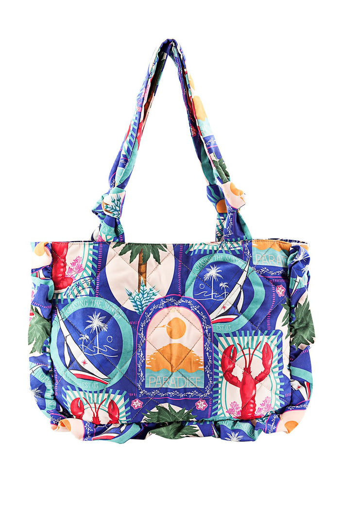 Quilted tote bag with ruffled edges and knotted shoulder straps in multicolor tropical print featuring palm trees, lobsters, sailboats, and vintage-s…