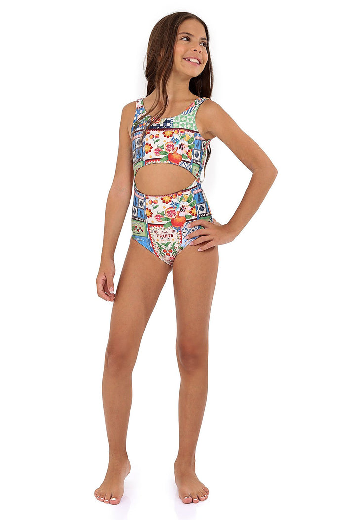 Girls one-piece swimsuit with front cutout, multicolor patchwork print featuring pattern detail panels, checkered sections, and fruit illustrations