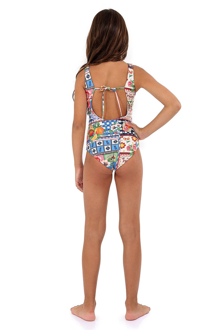 Ame one piece swimsuit in multicolor patchwork print with geometric tiles, florals, and polka dots, featuring an open cutout back detail