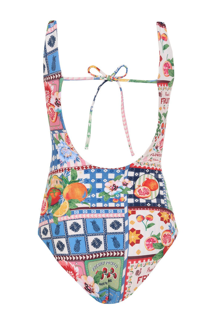 Girls' one-piece swimsuit with multicolor patchwork print featuring fruits, flowers, and geometric tile patterns, front cutout, and tie detail at back