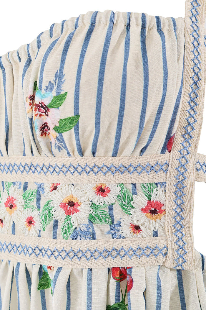 Ameli Dress in cream with blue vertical stripes, embroidered pattern detail details with coral and yellow blooms and green leaves, and geometric blue…
