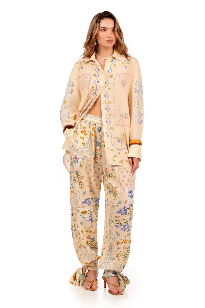 Cream long-sleeve shirt with embroidered pattern detail and geometric patterns along front placket and cuffs