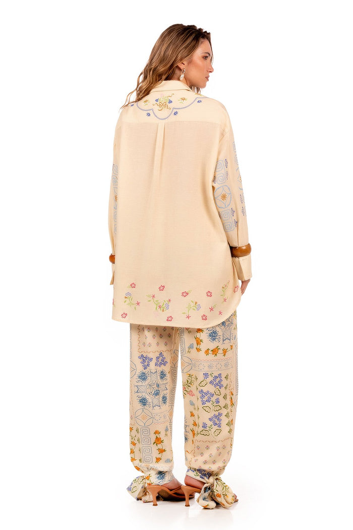 Cream Anastasia shirt with multicolor pattern detail embroidery on collar, hem, and sleeves, long sleeves with brown cuffs, button-up front