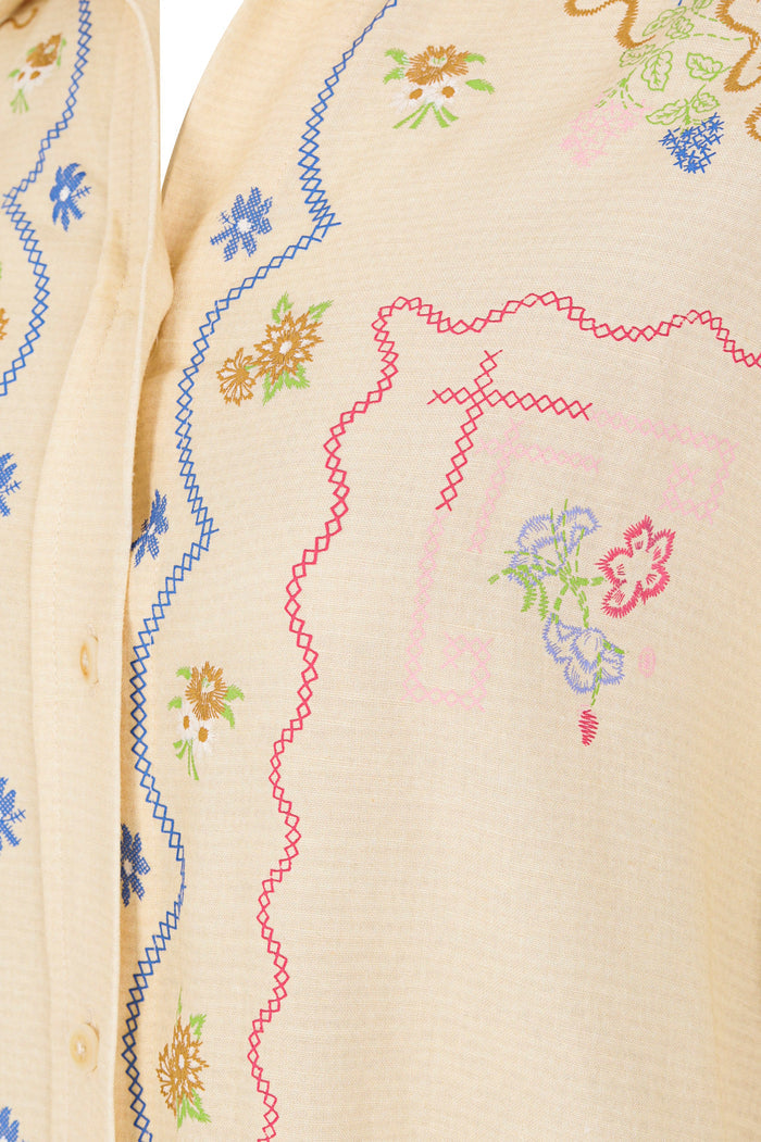Cream long-sleeve shirt with multicolored embroidered pattern detail details and zigzag trim along button placket