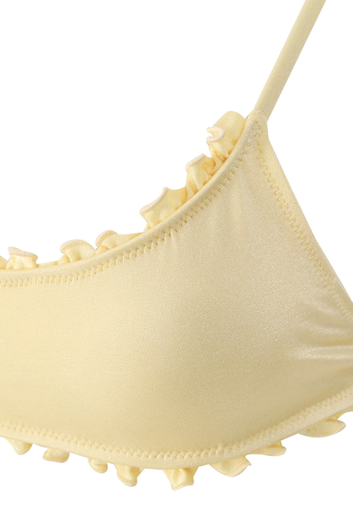 Pale yellow bikini top with ruched details and ruffled edges along adjustable straps