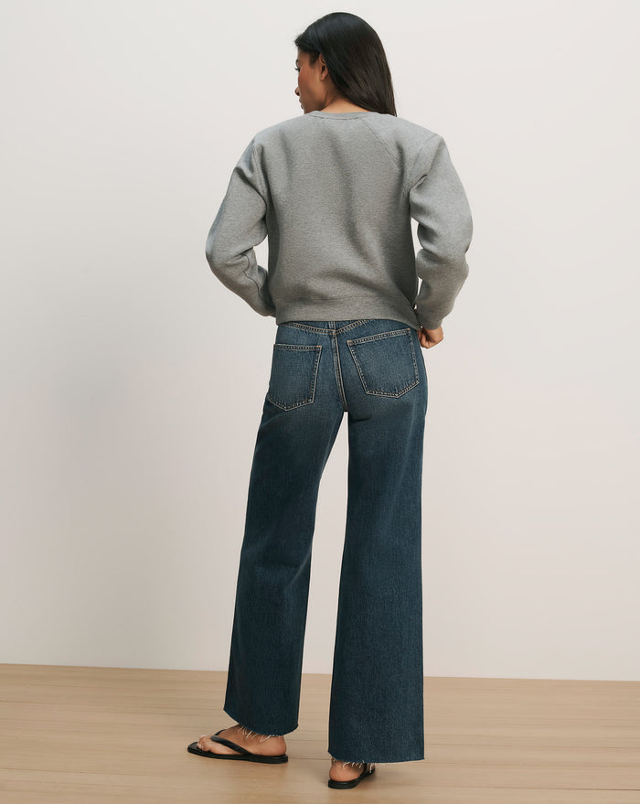 Veronica Beard Gray crewneck sweatshirt and dark wash wide-leg jeans.