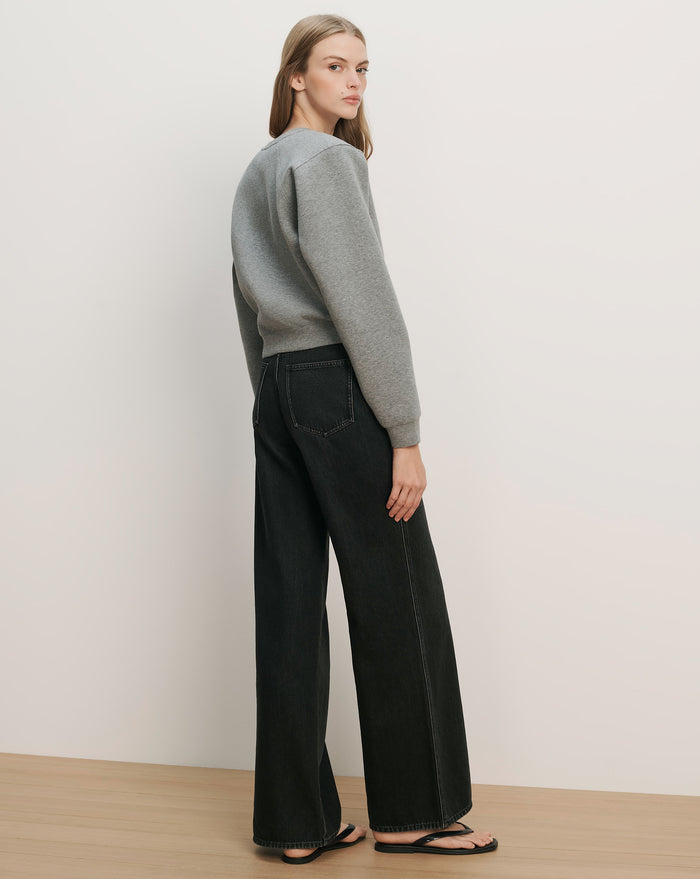 Veronica Beard Gray crewneck sweatshirt and black wide-leg jeans with white stitching.