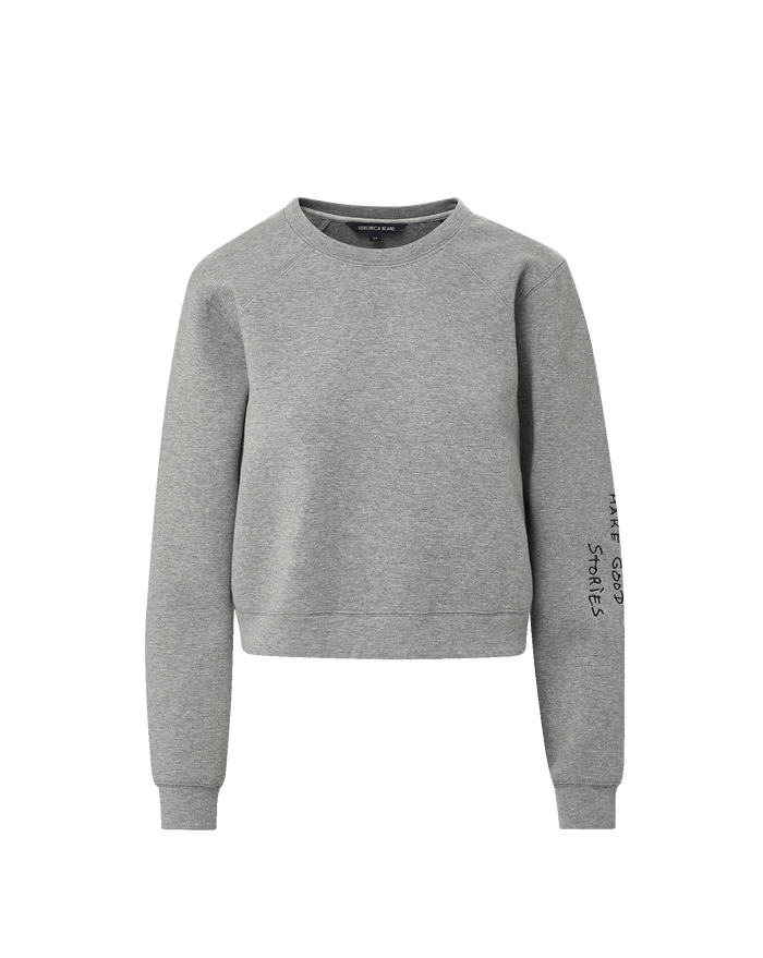 Veronica Beard Gray crewneck sweatshirt and black wide-leg jeans with white stitching.