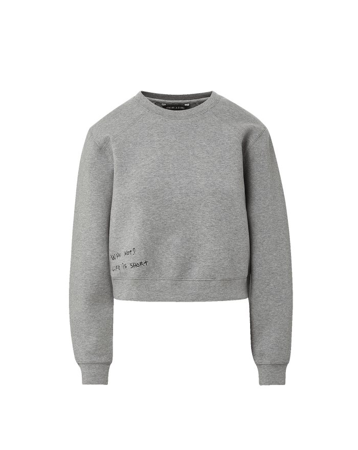 Veronica Beard Gray crewneck sweatshirt with raglan sleeves and dark wash wide-leg jeans with a raw hem.
