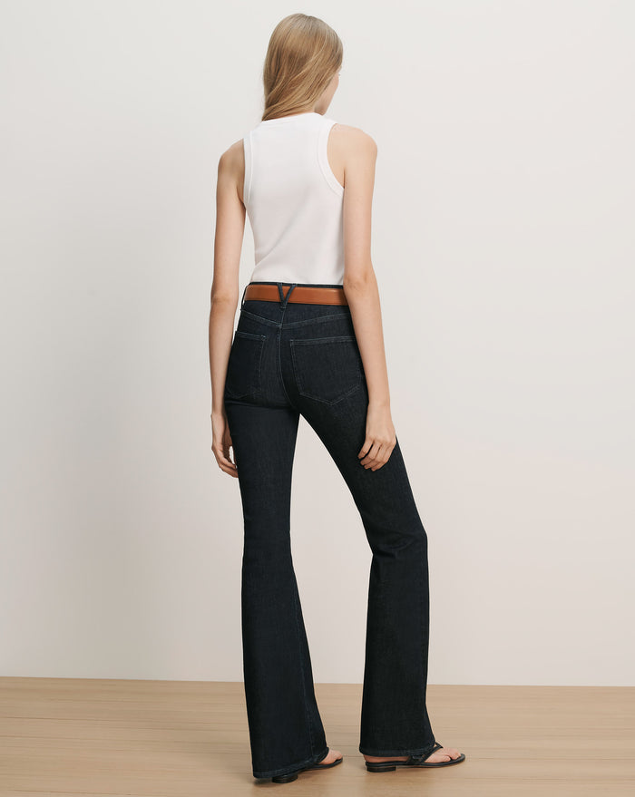 Veronica Beard White ribbed tank top, dark wash flared jeans with a brown belt.