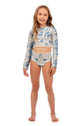 Girls' long-sleeve rashguard set in cream with blue tile-inspired pattern detail print and lace trim, includes crop top and high-waisted bottom