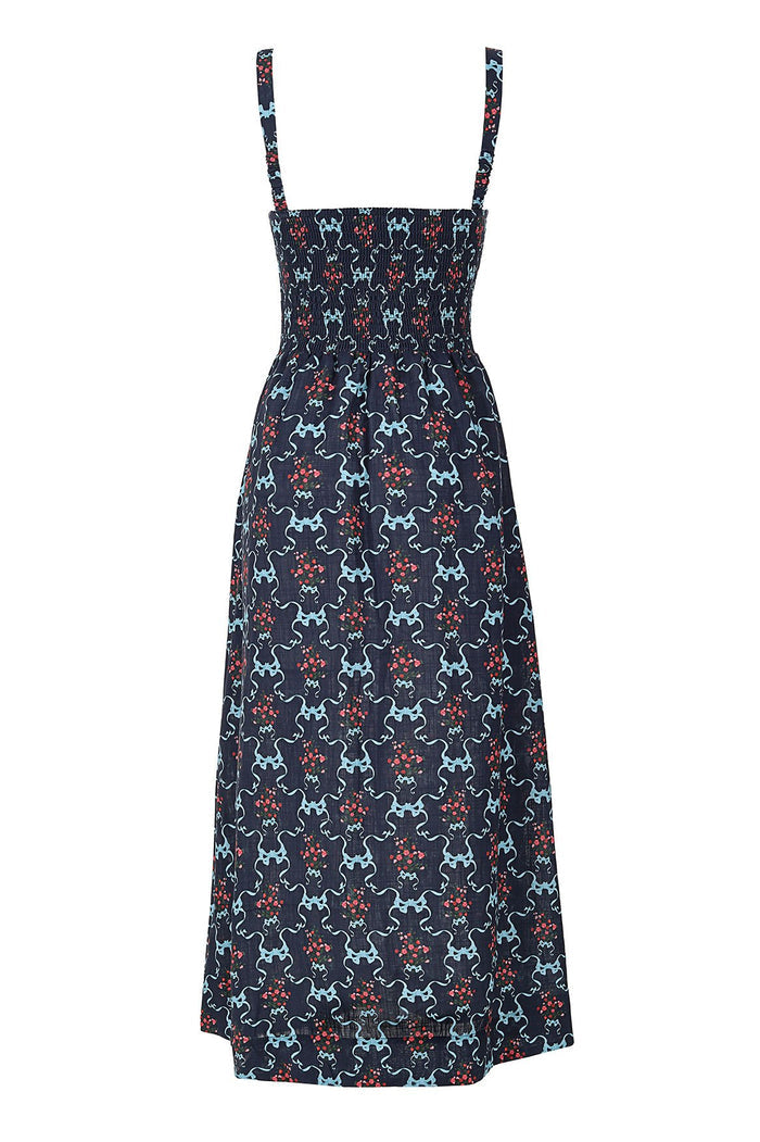 Navy smocked midi dress with geometric print featuring light blue curved lines and coral pattern detail clusters