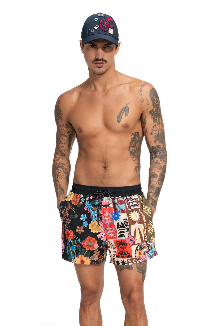 Men's swim trunks with black elastic waistband and vibrant mixed-panel print combining floral blooms and graphic patches