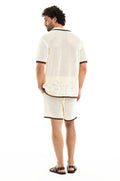Cece men's shorts in cream crochet-like knit fabric with brown contrast trim, shown from back with matching shirt