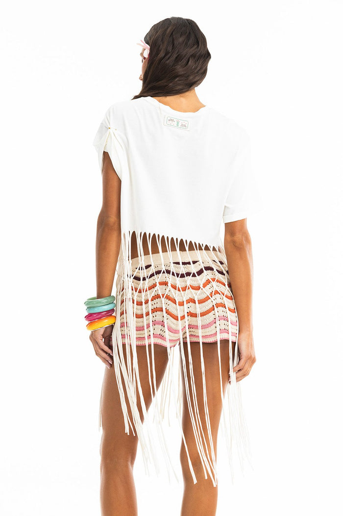 White cotton t-shirt with long handwoven fringe trim at hem, back view