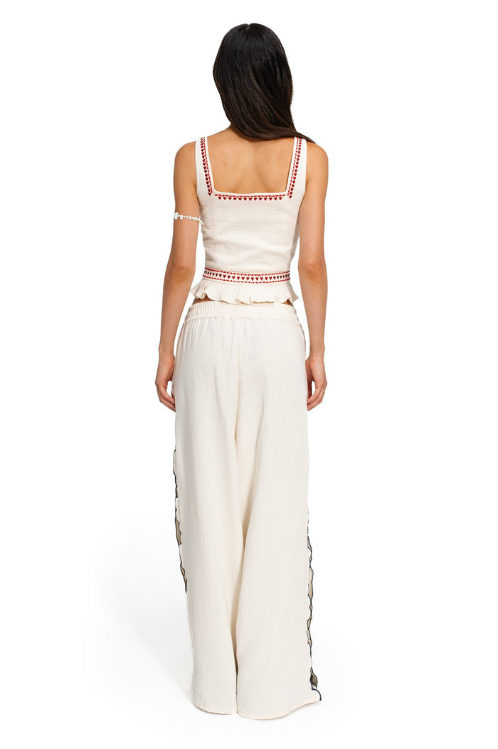 Back view of Charlotte crop top and wide-leg pants in ivory with red embroidered triangle trim, ruffle waist detail, and embroidered side seams