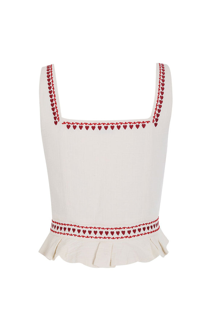 White crop top with red heart embroidery trim along square neckline, straps, and waist, finished with ruffle hem