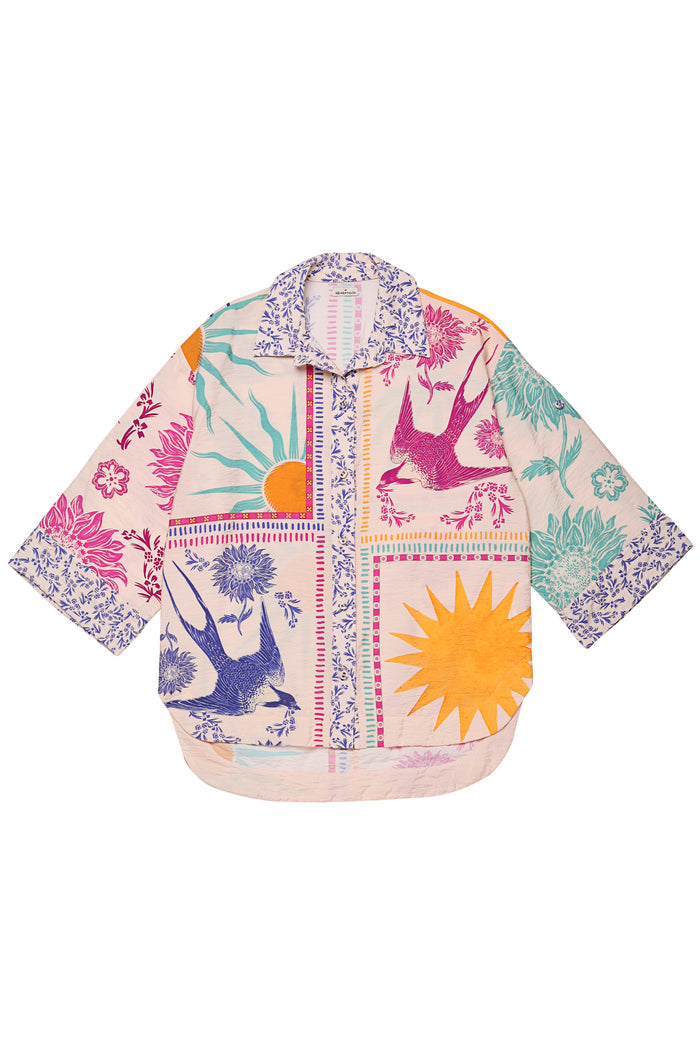 Chrissy Shirt with placement print featuring pink and blue birds, orange sun bursts, pattern detail elements, and decorative striped borders on cream…