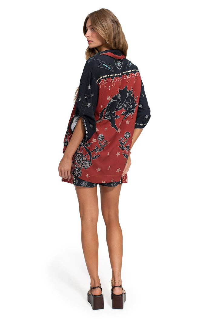 Back view of Chrissy Shirt in red and navy color-blocked panels with white dotted horses, rose outlines, and star details with bead embellishments