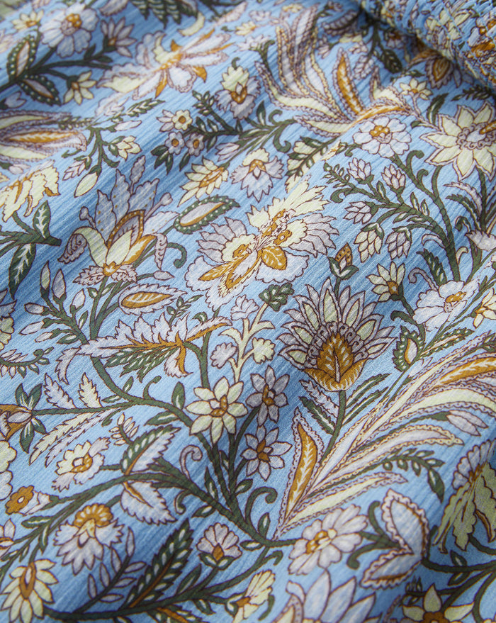 Veronica Beard Light blue floral print fabric with white, yellow, and green flowers and leaves.