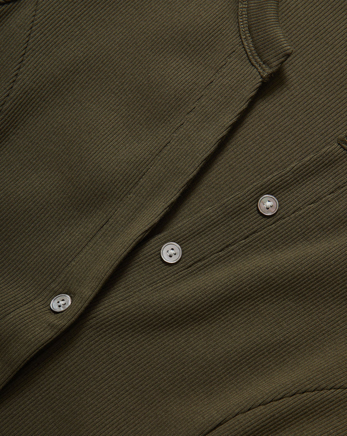 Veronica Beard Olive green ribbed knit cardigan, blue flared jeans.