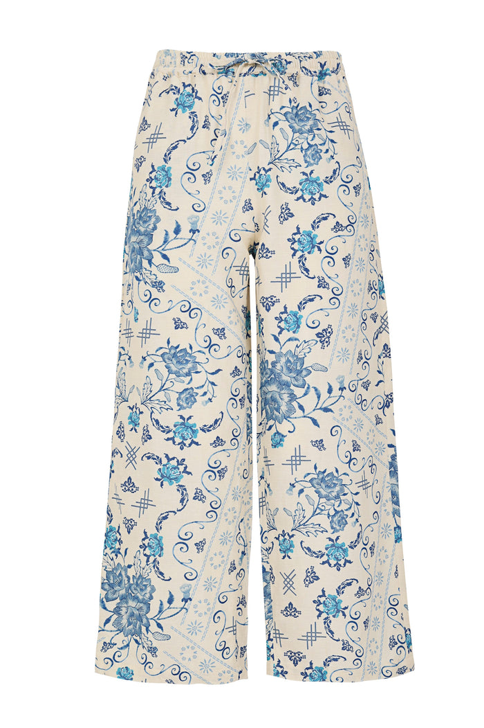Wide-leg pants in cream with blue pattern detail print featuring scrollwork, crosshatch details, and drawstring waist