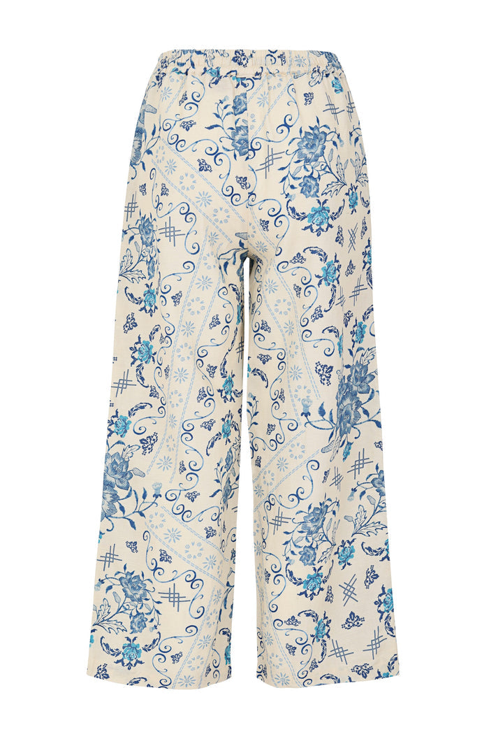 Wide-leg pants in cream with blue pattern detail print featuring scrolls, starburst details, and crosshatch accents