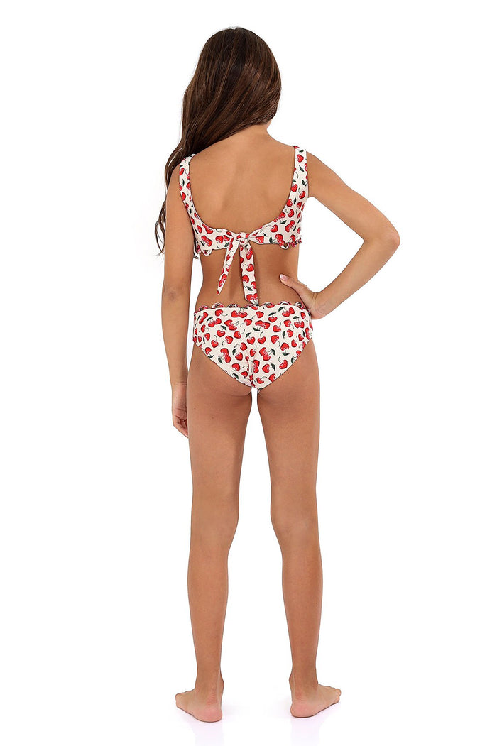 Dolce Kids' Bikini Set with red fruit print on white base, scalloped trim detail, back view showing tie closure and matching bottoms