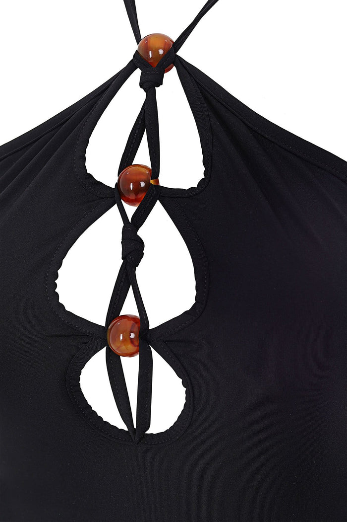 Black halterneck maxi dress with front cutouts accented by amber beaded details