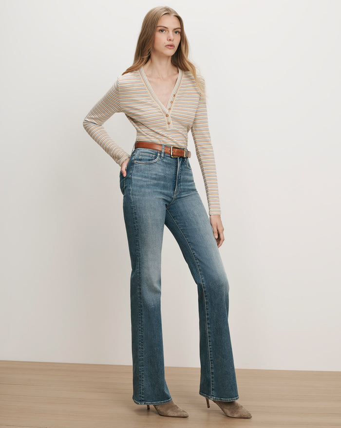 Veronica Beard Striped long-sleeve henley, blue flare jeans, brown belt.