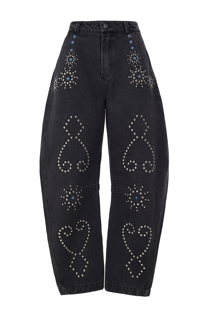 Black denim wide-leg pants with silver rhinestone and stud embellishments forming geometric scroll patterns and starburst details on both legs