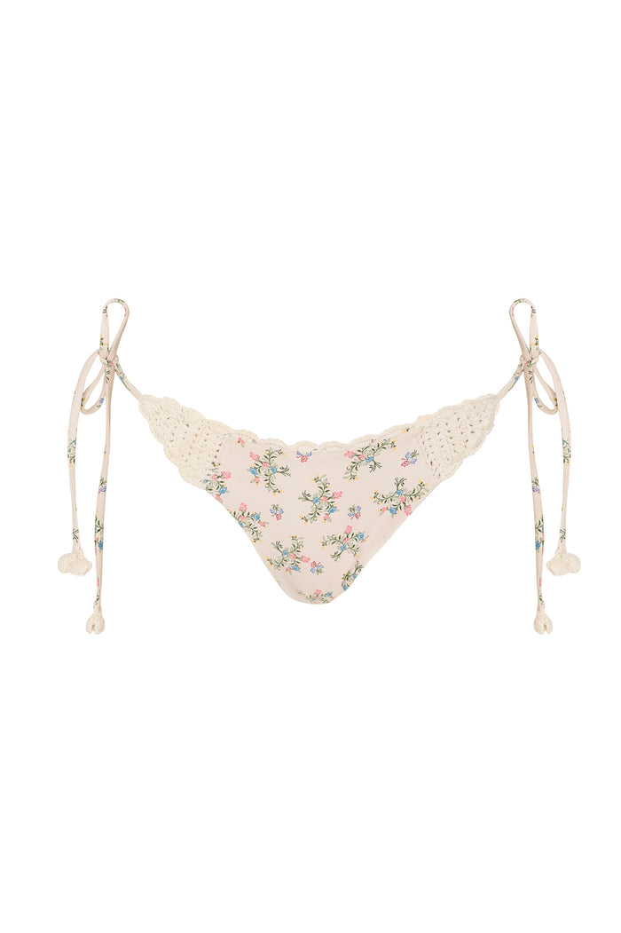 Fawna bikini bottom in blush pink with small pattern detail print, handmade crochet trim at waist, and adjustable side ties with pom-pom tassels