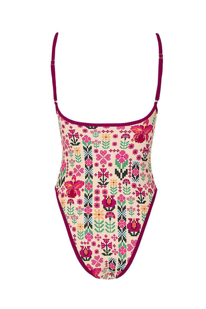 One-piece swimsuit with beige base and pixelated cross-stitch style print featuring pink, coral, green, and black pattern detail and geometric patter…