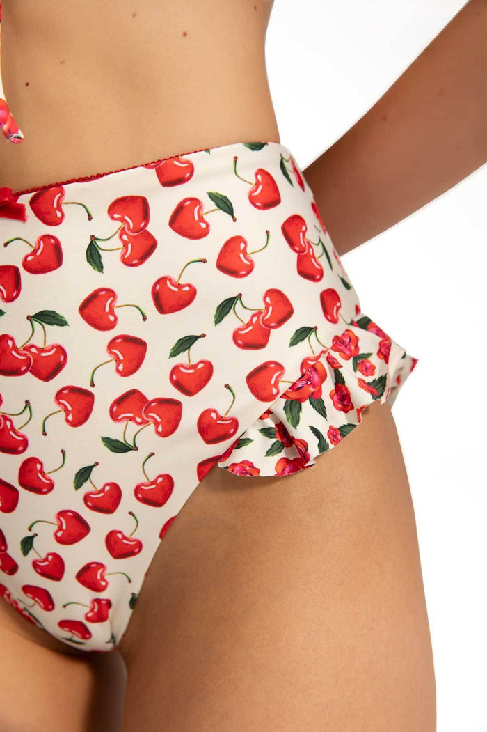 High-waisted bikini bottom in cream with red cherry print and ruffle details