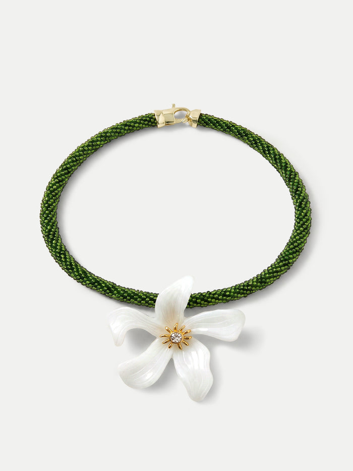 Veronica Beard Green beaded necklace with a white flower pendant.