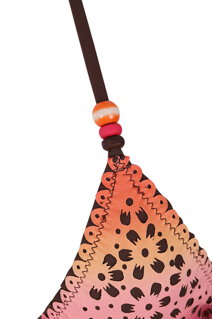 Gaia triangle bikini top in gradient orange to pink with brown spotted pattern, zigzag trim edges, wooden and coral beads on brown strap