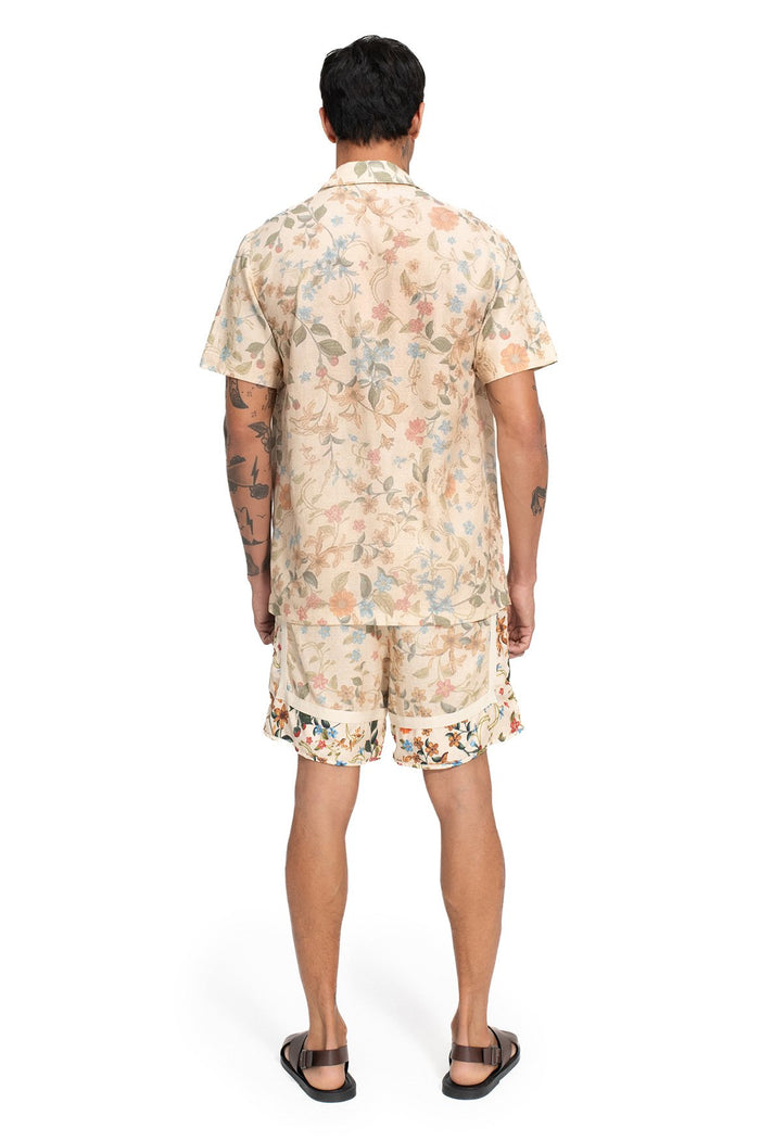 Back view of Georgie men's shorts in cream with all-over floral print featuring soft pink, blue, and olive leaves and blooms