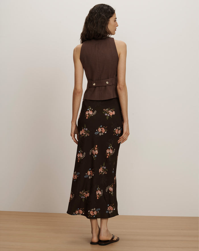 Veronica Beard Brown sleeveless vest with silver buttons and a black floral midi skirt.