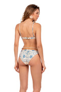 Ilu bikini bottom in cream with blue tile-inspired geometric print, back view with adjustable ties and ruffle trim at waist