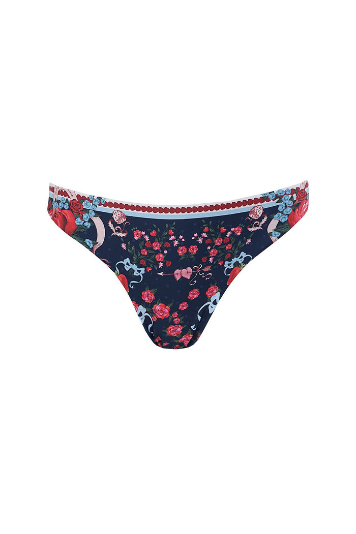 Reversible bikini bottom in navy with red roses, blue ribbons, and pink pattern detail print, featuring scalloped burgundy trim at waistband