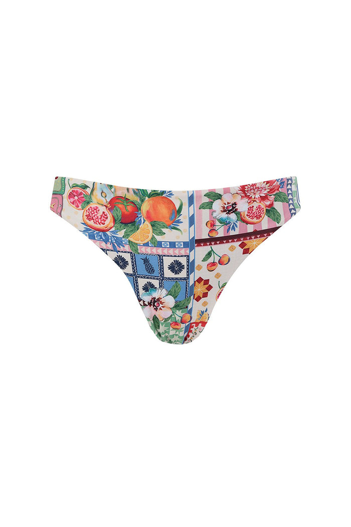 Ilu bikini bottom in reversible multicolor print featuring pomegranates, peaches, florals, cherries, and pineapple with geometric tile accents