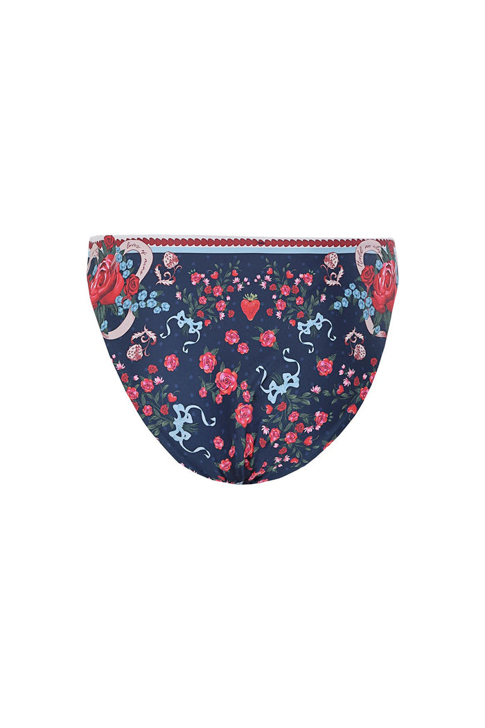 Navy bikini bottom with reversible print featuring red roses, blue silhouettes, and heart details with scalloped red trim