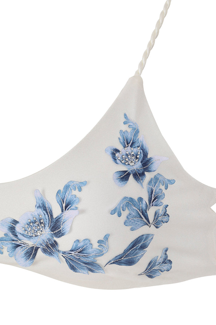 White bikini top with blue floral appliqués and beaded centers, braided straps