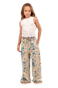White sleeveless top with blue circular embroidery pattern and matching beige wide-leg pants with blue pattern detail print
