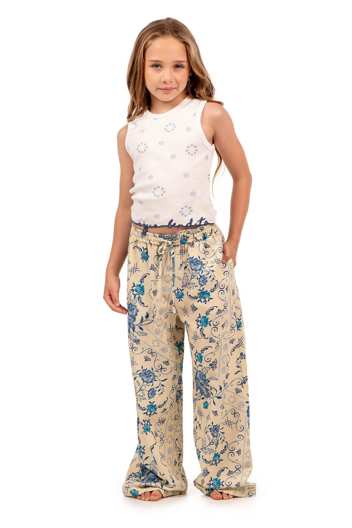 White sleeveless top with blue circular embroidery pattern and matching beige wide-leg pants with blue pattern detail print